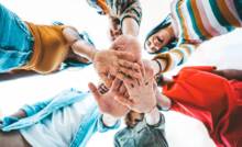 Giovani uniscono le mani in segno di unione