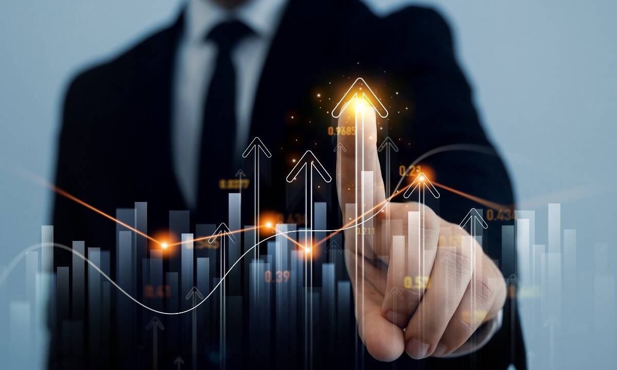 Analisi positiva: uomo in giacca e cravatta indica un grafico di borsa in crescita.