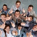 Successo del team: vista dall'alto di colleghi felici con il pollice alzato.