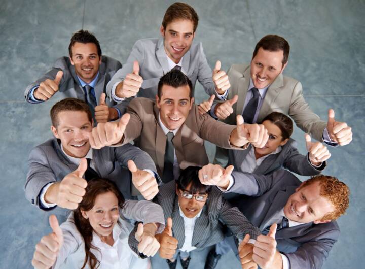 Successo del team: vista dall'alto di colleghi felici con il pollice alzato.